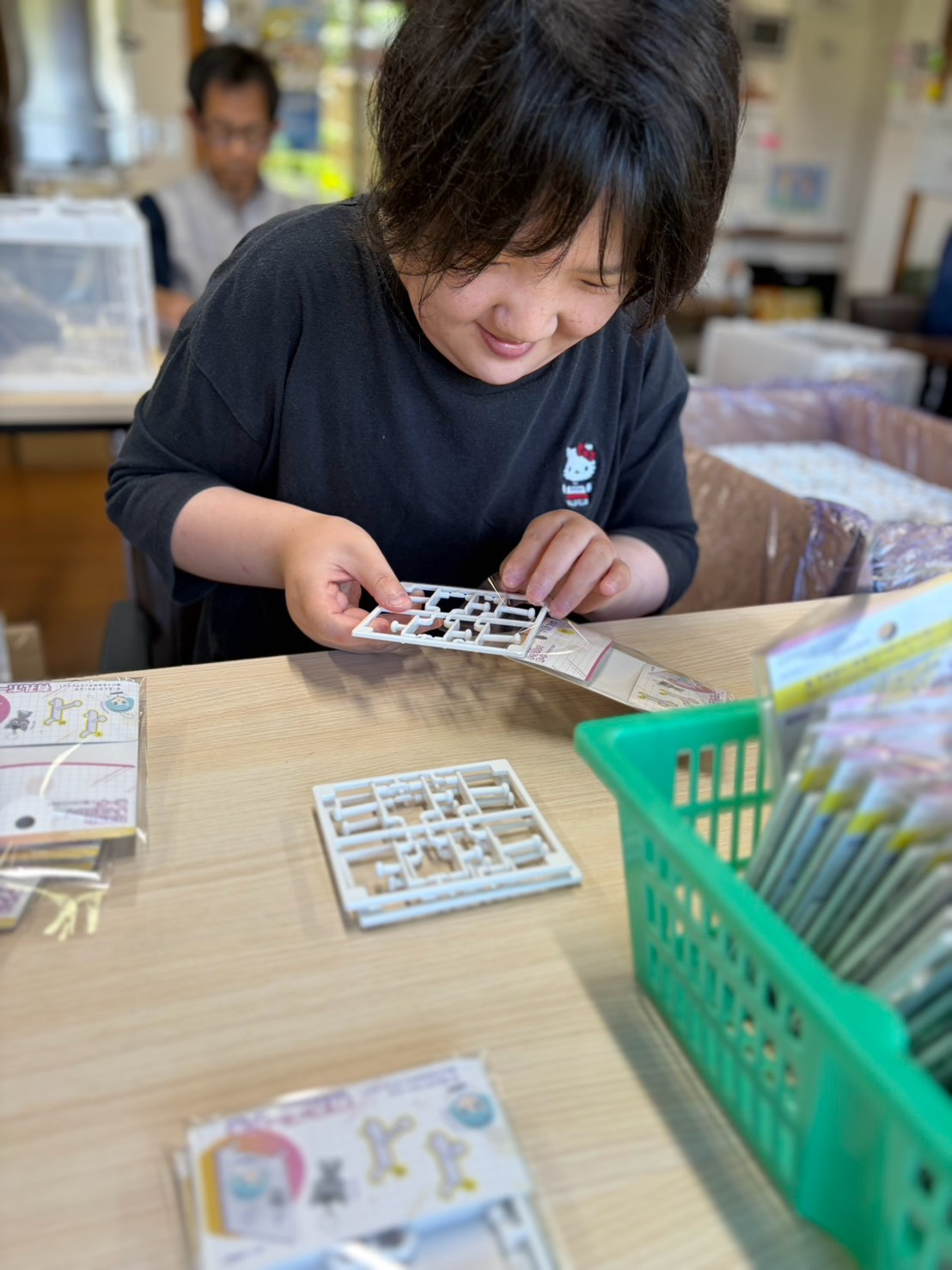 奈良県天理市の就労継続支援B型事業所「てん」で、笑顔を浮かべながら小さな部品の組み立て作業に取り組む利用者の様子。